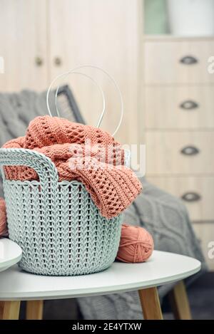 Korb mit Strickprojekt in Arbeit und Garn auf Kaffee Tisch in häuslichen Innenräumen Nahaufnahme Stockfoto