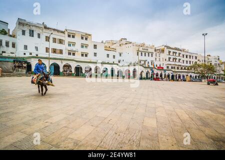 Moulay Idriss, Marokko - 10. April 2015. Mann, der auf dem Esel in der Mitte des leeren Hauptplatzes reitet Stockfoto