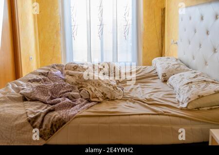 Blick auf das Doppelzimmer, in dem sich das ungefertigte Bett befindet. Selektiver Fokus. Home-Konzept Stockfoto