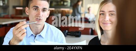 Lächelnde Menschen diskutieren im Café über Arbeitsfragen Stockfoto