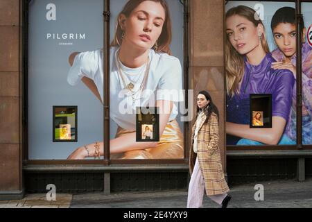 Edinburgh, Schottland, Großbritannien. 25. Januar 2021. Das Kaufhaus Jenners in der Princes Street in Edinburgh kündigt an, dass es am 3. Mai mit Verlust von 200 Arbeitsplätzen dauerhaft schließen wird. Fraser, sein Besitzer, sagt, dass es nicht gelungen ist, mit dem Bauherren anders Polvsen eine Miete zu vereinbaren. PIC; ein Mitglied der Öffentlichkeit geht heute an der Schaufenstervorführungen im geschlossenen Jenners-Laden vorbei. Iain Masterton/Alamy Live News Stockfoto