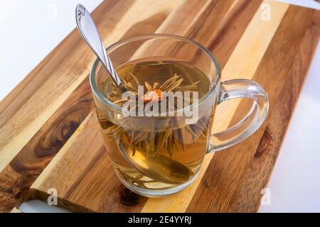 Blühender Tee in einem transparenten Becher.blühender Blumentee Stockfoto