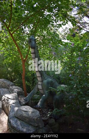 Dinosaurier-Statue im Waldpark in der Natur für Hintergrund. Kleine Dinosaurierstatuen in einem Wald. Dinopark in der Türkei, Goynuk. Stockfoto