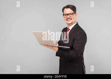 Business, Gadgets, Technologien. Mann, der auf dem Schoß arbeitet. Indoor, Studioaufnahme, isoliert auf grauem Hintergrund Stockfoto