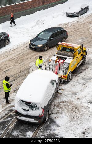 Auto wird abgeschleppt, um Schneeräumung und Entfernung auf Messeniuksenkatu im Taka-Töölön Bezirk in Helsinki, Finnland zu ermöglichen Stockfoto