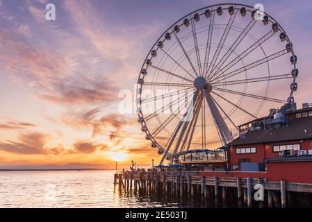 Das Seattle Great Wheel steigt 175 Meter über Pier 57, mit Blick auf die Skyline von Seattle und Elliott Bay, wenn die Sonne im Westen untergeht Stockfoto