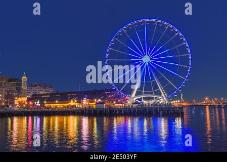 Das Seattle Great Wheel steigt 175 Meter über Pier 57, mit Blick auf die Skyline von Seattle und Elliott Bay, wenn die Sonne im Westen untergeht Stockfoto