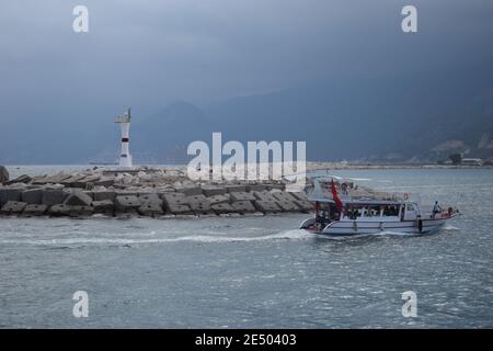 Leuchtturm am Eingang des Yachthafens von Antalya. Touristenboot im Meer in der Nähe des Leuchtturms im Hafen. Antalya Türkei. September 2020, 26 Stockfoto