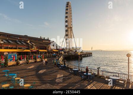 Das Seattle Great Wheel steigt 175 Meter über Pier 57, mit Blick auf die Skyline von Seattle und Elliott Bay, wenn die Sonne im Westen untergeht Stockfoto