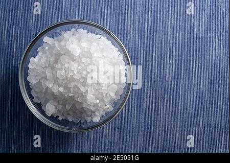 Glasschale mit Meersalz auf weißem und blauem Hintergrund Mit leerem Raum Stockfoto