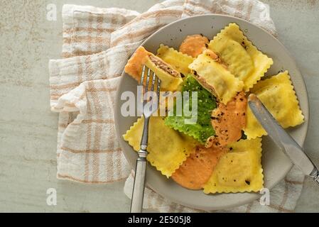 Ravioli Pasta mit Gemüsesoße aus nächster Nähe serviert. Kleine Nudelumschläge mit Hackfleisch, Käse und Gemüse Stockfoto