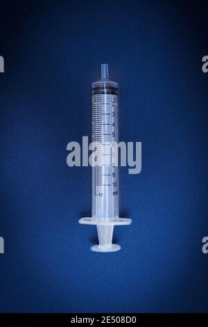 Medizinische Einmalspritze. Anwendbar für Impfstoffinjektion isoliert auf dunklem Hintergrund Stockfoto