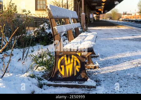 Royal Leamington Spa, Warwickshire, Großbritannien. 25. Januar 2021: Nach einem Tag Schneefall ist der Landkreis zu einer frostigen Winterlandschaft aufgewacht. Die Bahnsteige der Leamington Spa Station wurden gesalzen, sind aber immer noch rutschig und stellenweise sehr verschneit. Der Garten des Bahnhofs glitzert von Schnee, wie auch die charakteristischen Bänke der GWR (Great Western Railway). Kredit: Ryan Underwood / Alamy Live Nachrichten Stockfoto