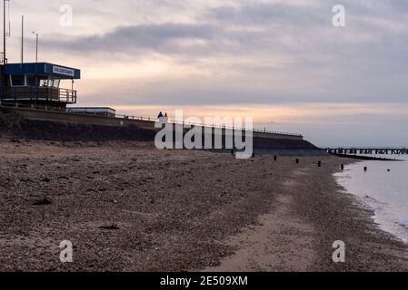 HM Coastguard Post bei Shoeburyness mit Blick auf den Mod Beach für die Öffentlichkeit wegen des Schießstandrisikos in der Nähe geschlossen. Menschen, die entlang der Ufermauer spazieren Stockfoto