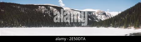 Ein gefrorener See am Fuße einer kleineren Kette von Bergen, Rocky Mountain National Park, Colorado, USA Stockfoto