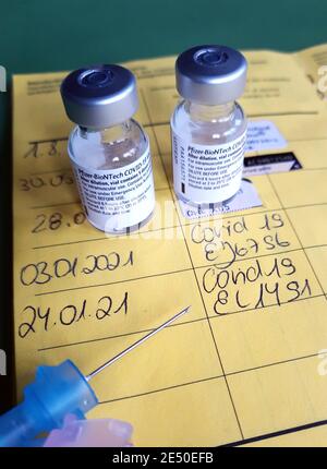 Symbolbild Corona-Impfung. Zwei Impfdosen, Impfritze und der Eintrag der ersten und zweiten Corona-Impfdung in einem Impfpass einer mit dem COVID-19-mRNA-Impfstoff der Firma BioNTech geimpften Person. Dortmund, 25.01.2021 --- Corona-Impfsymbole. Zwei Impfdosen, Impfspritze und Eintrag der ersten und zweiten Coronaimpfung in einen deutschen Impfpass einer mit dem COVID-19 mRNA-Impfstoff von BioNTech geimpften Person. Dortmund, den 25th. Januar 2021 Stockfoto