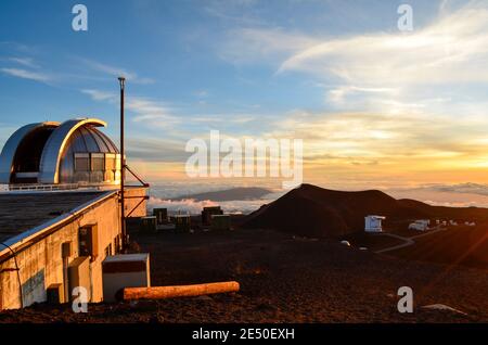 Blick vom Gipfel des Mauna Kea Hawaii, über die Wolken bei Sonnenuntergang. Mit Weltraumteleskopen auch auf dem Berg. Stockfoto