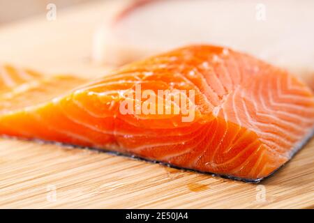 Rohes Lachsfilet auf einem Schneidebrett. Stockfoto