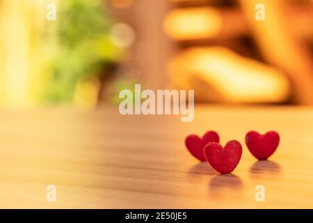 Nahaufnahme rote Herzen werden auf dem Tisch im Garten platziert. Valentinstag Hintergrund und Textur. Stockfoto