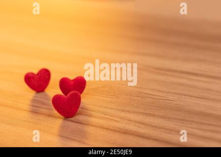 Nahaufnahme rote Herzen sind auf dem Holztisch platziert. Valentinstag Hintergrund und Textur. Stockfoto