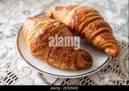 Zwei frisch gebackene Blättercroissants, traditionelles französisches Frühstück aus nächster Nähe Stockfoto