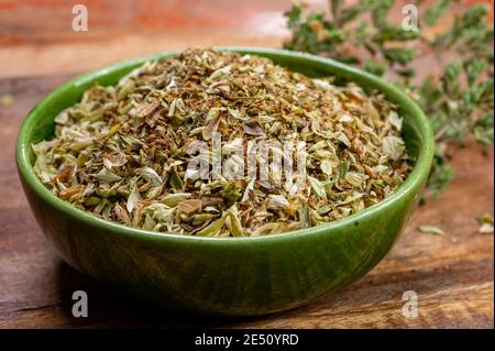 Getrocknete aromatische Küche Kräuter Oregano in grüner Schale aus nächster Nähe Stockfoto