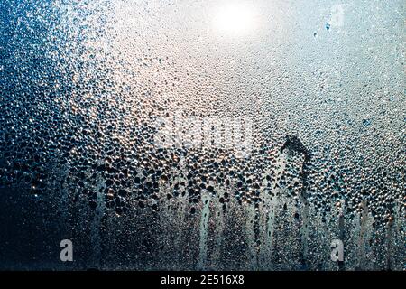 Vernebelt Fenster mit Tropfen Feuchtigkeit, die in der Sonne leuchtet.Textur, Vorlage für Text. Stockfoto