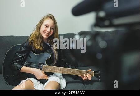 Teenagermädchen mit semi-akustischer Gitarre vor der Videokamera. Stockfoto