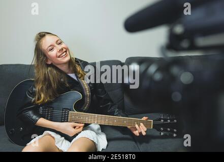 Teenagermädchen mit semi-akustischer Gitarre vor der Videokamera. Stockfoto