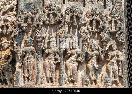 Lakkundi, Karnataka, Indien - 6. November 2013: Kasivivesvara Tempel. Beschädigte Reihe von weiblichen Figuren als Sockel am unteren Rand des Eingangsrahmens. Stockfoto