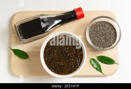 Chia-Samen mit Sojasauce und Nori-Algen auf einem hölzernen Schneidebrett auf einem weißen Teller. Veganes Snack-Konzept. Superfood. Draufsicht Stockfoto