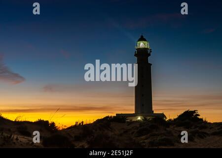 Ein Blick auf den Cape Trafalgar Leuchtturm signalisiert Licht nach Sonnenuntergang mit buntem Abendhimmel Stockfoto