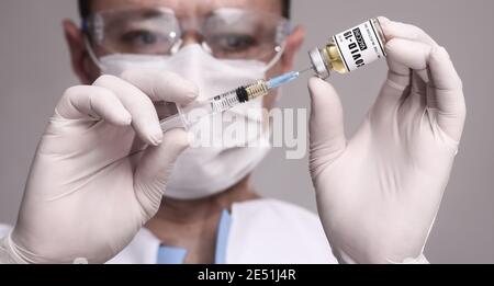 COVID-19. Arzt Wissenschaftler sammelt den Impfstoff, um den Patienten zu impfen. Männlicher Forscher testen Impfstoff im Labor. Stockfoto