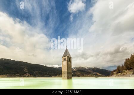 Symmetrische Weitwinkelansicht des legendären versunkenen Glockenturms Von Curon umgeben vom Wasser des Reschensees Stockfoto