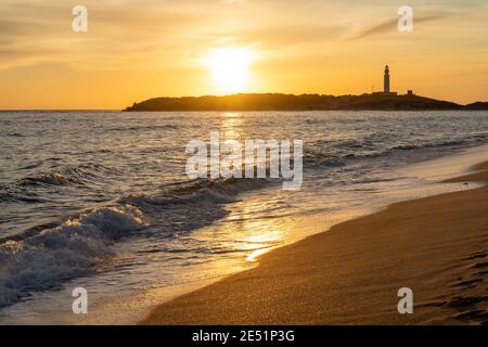 Friedlicher Sonnenuntergang am Strand Playa de Maria Sucia mit Der Cape Trafalgar Leuchtturm im Hintergrund Stockfoto
