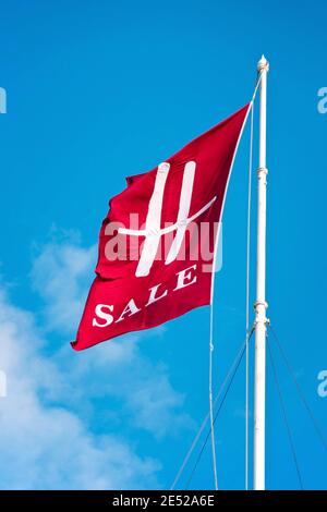 Harrods Verkaufsflagge mit blauem Himmel im Hintergrund. Harrods ist ein Kaufhaus an der Brompton Road in Knightsbridge. Stockfoto