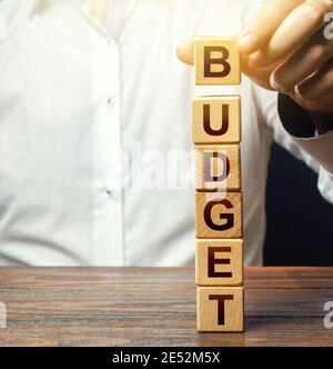 Man baut einen Turm von Blöcken mit Wort Budget. Budgetierung, Ertragsprognose und Kostenoptimierung. Planungsaufwand für das neue Geschäftsjahr. Selbstklebend Stockfoto