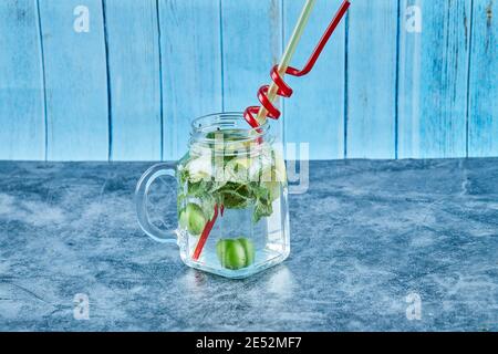 Mojito Cocktail mit Limettenscheiben und Minze auf Blau Tabelle Stockfoto