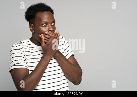 Überrascht afro Mann macht große Augen öffnet, deckt ihren Mund schockiert Blick auf Copy Raum, Angebot, Verkauf Stockfoto