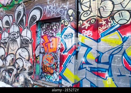 Eine große Anzahl von bunten Wandmalereien, die zu einer ungewöhnlichen Touristenattraktion in einer Gegend geworden sind, die als Graffiti Alley in Toronto Ontario Canada bekannt ist Stockfoto