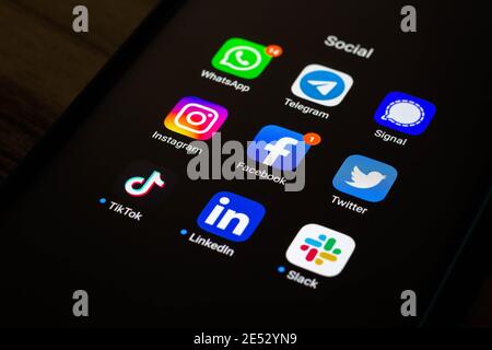 In dieser Abbildung sehen Sie die Whatsapp, Telegram, Signal, Instagram, Facebook, Twitter, Tik Tok, LinkedIn und Slack App und Logos auf einem Smartphone. Stockfoto