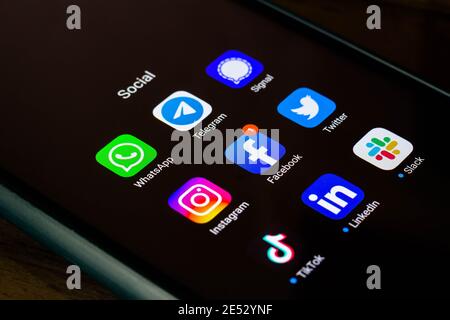 In dieser Abbildung sehen Sie die Whatsapp, Telegram, Signal, Instagram, Facebook, Twitter, Tik Tok, LinkedIn und Slack App und Logos auf einem Smartphone. Stockfoto