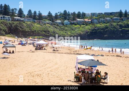 Sonnenbaden am Bilgola Beach Sydney während der heißen australischen Sommer und Mit Cabanas und Schirmen für Sonnenschutz und Schatten, Sydney Stockfoto