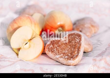 Glasierte Lebkuchen in Herzform. Picknick in der Natur, leichter Snack mit Äpfeln und Plätzchen.Valentinstag Backwaren. Selektiver Fokus Stockfoto