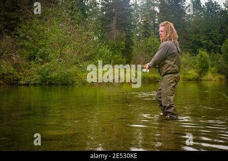 Dieser junge Mann genießt einen ruhigen Nachmittag des Fischens auf dem Kijik Fluss im Südwesten Alaskas. Stockfoto