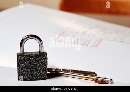 Metallschloss und Schlüssel aus dem neuen Haus lagen auf dem Wohnungsplan. Verkauf von Immobilien und Symbole Stockfoto