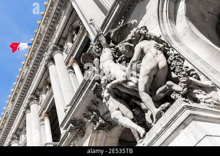 Nahaufnahme einer Gruppe von Marmorstatuen an der Fassade eines französischen Gebäudes mit einer französischen Flagge im Hintergrund Stockfoto