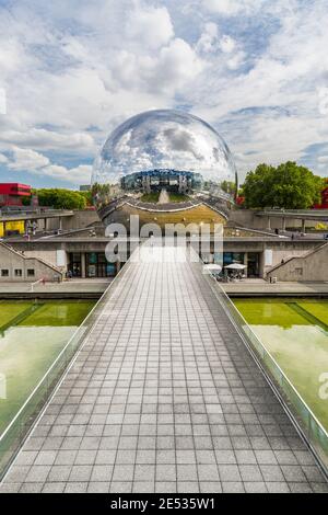 Symmetrische Weitwinkelansicht eines Betonwaldes, der zum Geode-Kino führt, in einer riesigen Chromkugel untergebracht Stockfoto