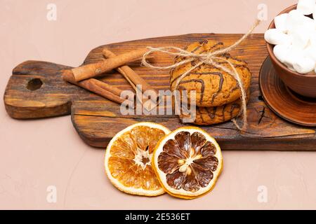 Herzförmige Haferflockenkekse auf einem alten Holzbrett. Kakao mit Marshmallows und getrockneten Orangen. St. Valentin's Day Konzept. Stockfoto