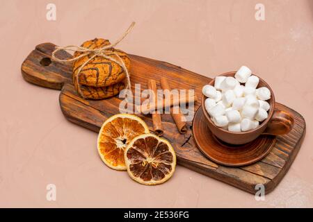 Frühstück am Valentinstag. Herzförmige Haferflockenkekse und Kaffee mit Marshmallows auf einem dunklen Vintage-Brett. Stockfoto